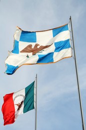 Photo of Mexico flags fluttering against blue sky on sunny day, low angle view