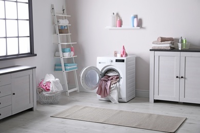 Photo of Bathroom interior with dirty towels in washing machine