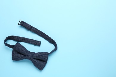 Photo of Stylish bow tie on light blue background, top view. Space for text