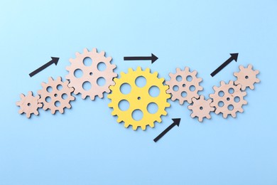 Photo of Business process organization and optimization. Scheme with wooden figures and arrows on light blue background, top view