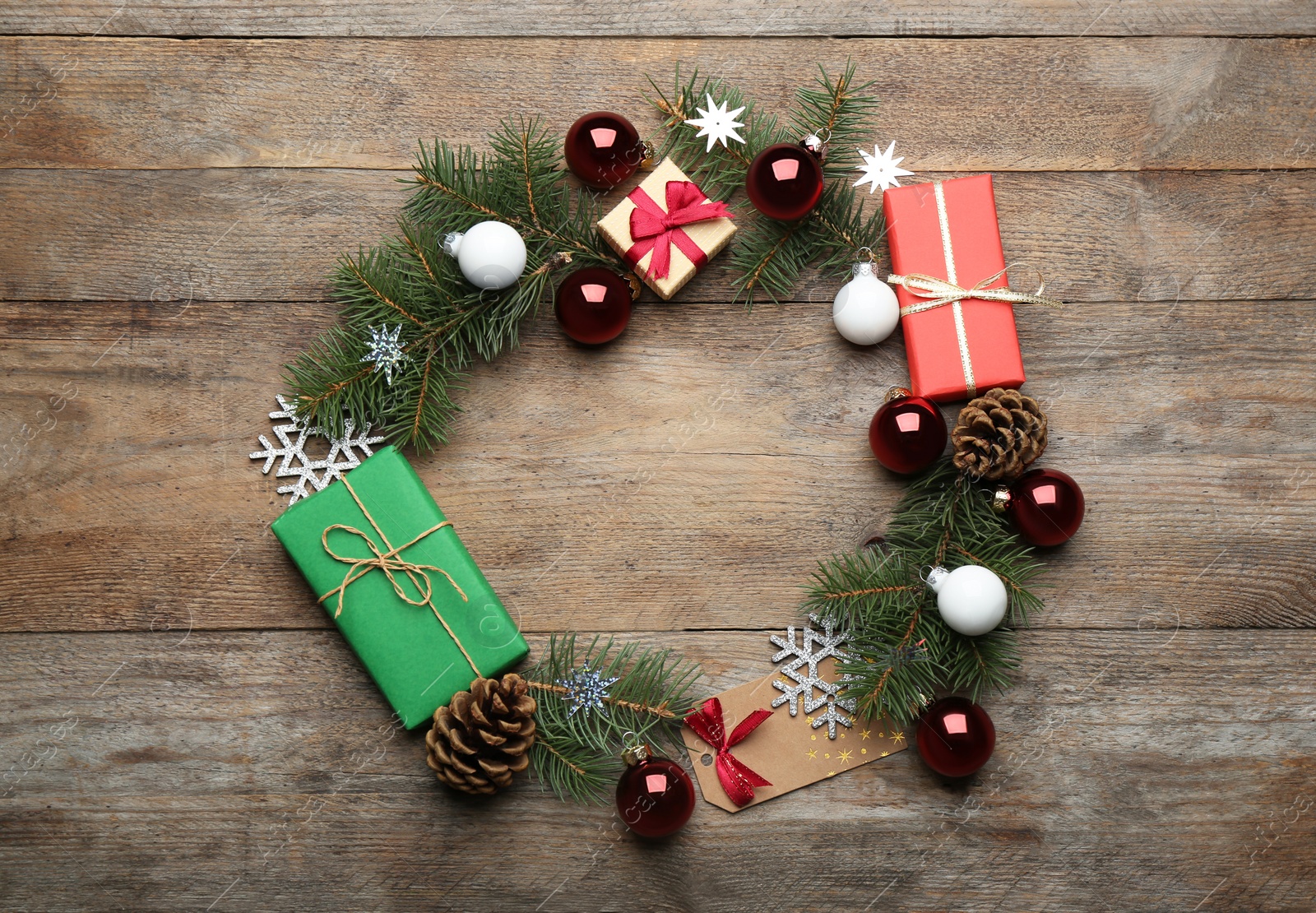 Photo of Frame made of Christmas decorations on wooden background, top view with space for text. Winter season