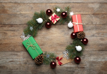 Photo of Frame made of Christmas decorations on wooden background, top view with space for text. Winter season