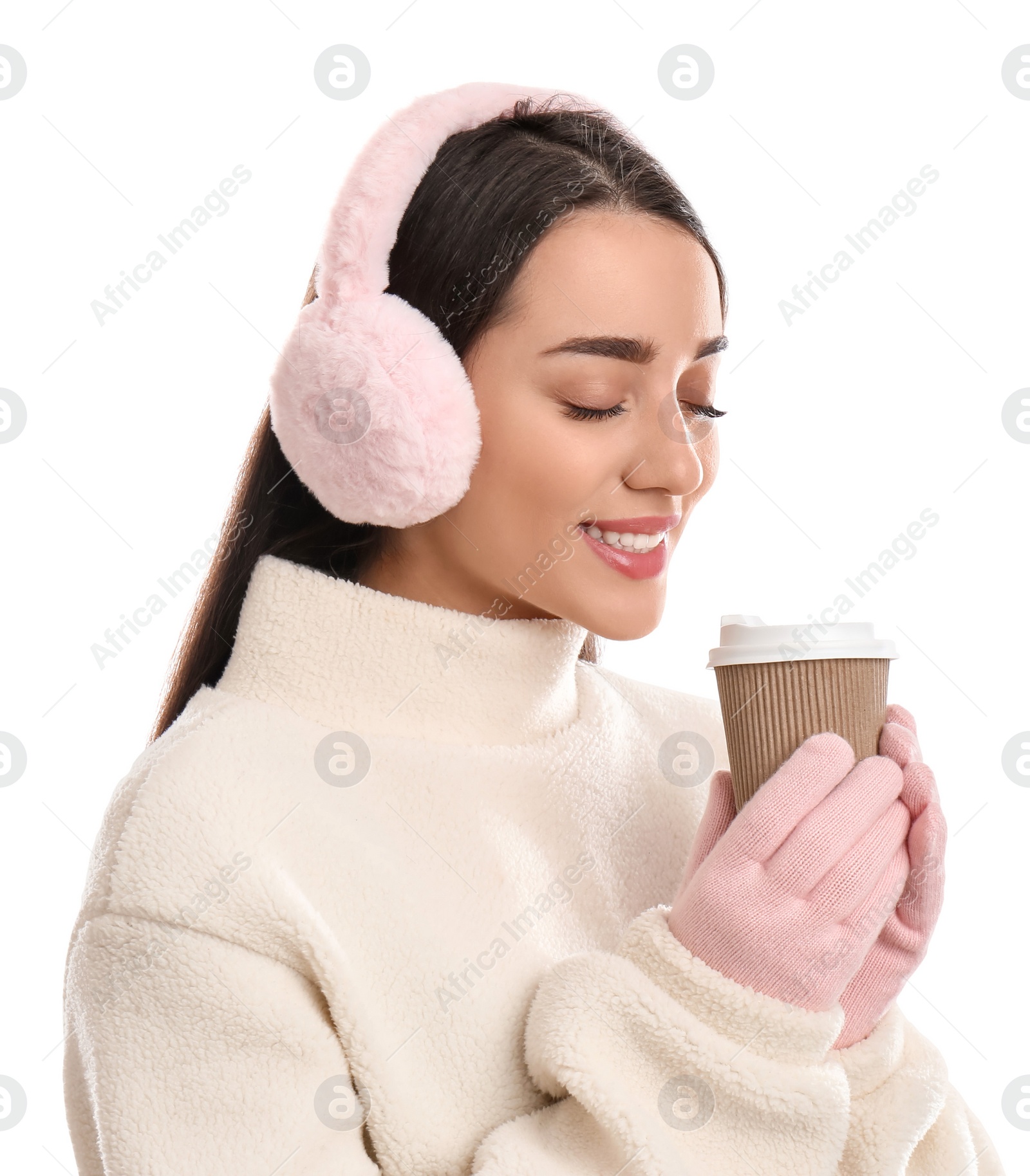 Photo of Beautiful young woman in earmuffs with cup of drink on white background