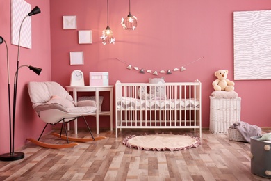 Photo of Modern baby room interior with crib and rocking chair