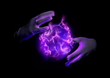 Image of Magician performing magic trick on black background, closeup