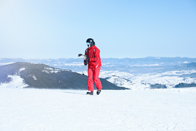 Photo of Male skier on snowy slope in mountains. Winter vacation