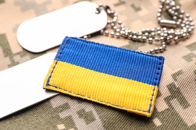 Photo of Military ID tags and patch on pixel Ukrainian camouflage, closeup