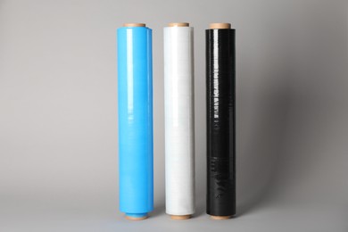 Photo of Rolls of different stretch wrap on light grey background