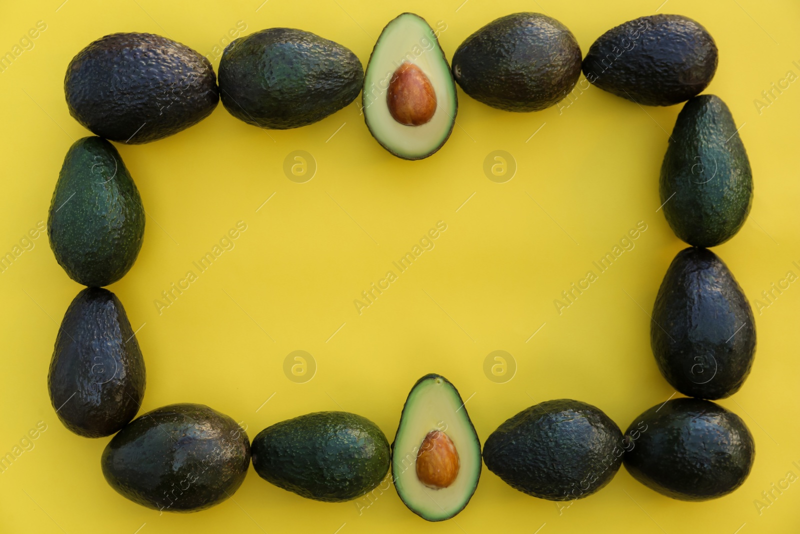 Photo of Frame of fresh whole and cut avocados on yellow background, flat lay. Space for text