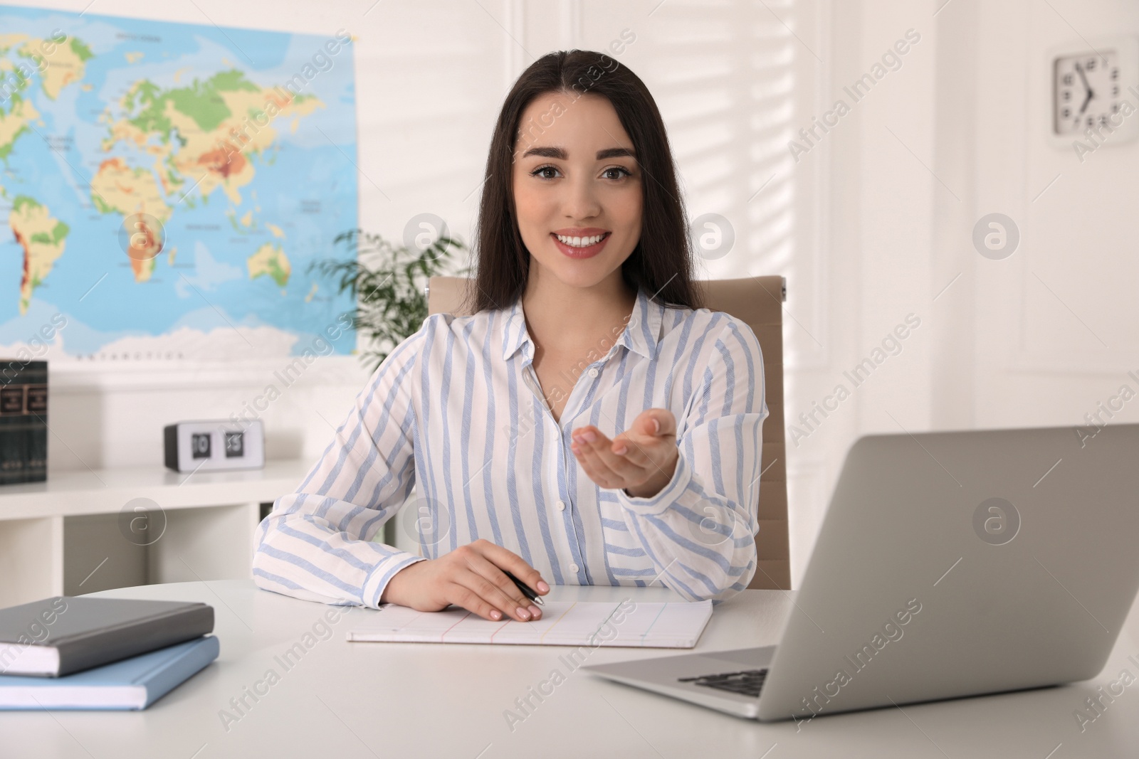 Photo of Happy manager sitting at desk in travel agency