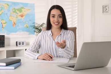 Happy manager sitting at desk in travel agency