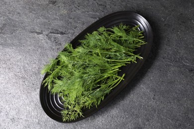 Photo of Sprigs of fresh green dill on grey table, top view