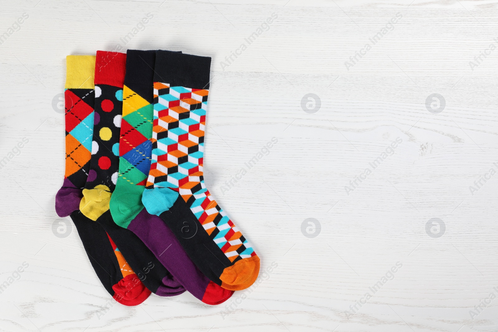 Photo of Flat lay composition with different socks and space for design on light wooden background