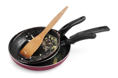 Photo of Dirty frying pans and wooden spatula on white background