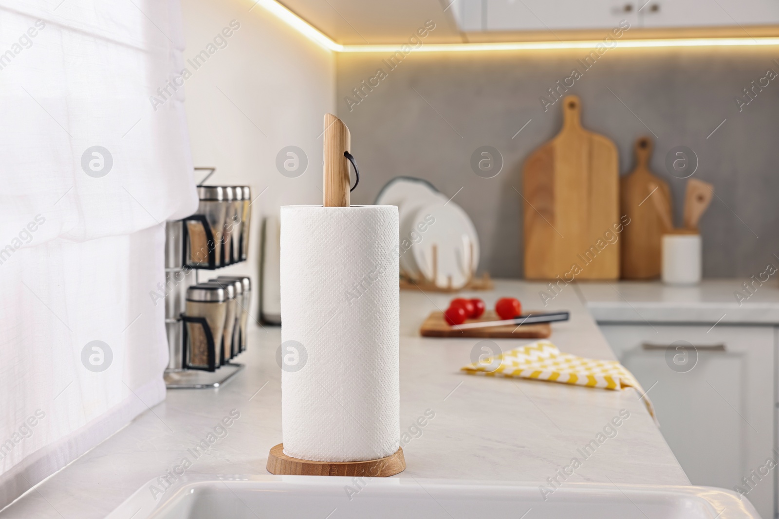 Photo of Roll of paper towels on white countertop in kitchen, space for text