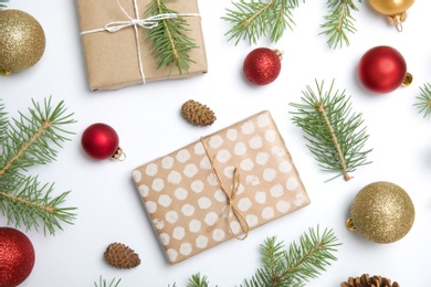 Composition with Christmas tree branches, festive decor and gift boxes on white background