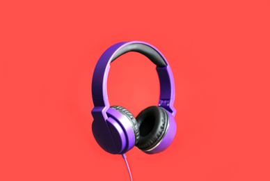 Stylish headphones with pads on color background