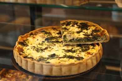Delicious spinach quiche on counter in bakery shop, closeup