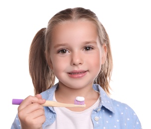 Photo of Little girl holding toothbrush with paste on white background