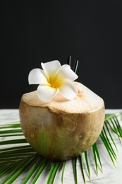 Photo of Fresh green coconut on table against dark background