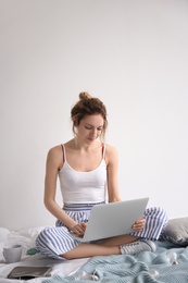 Female blogger with laptop on bed