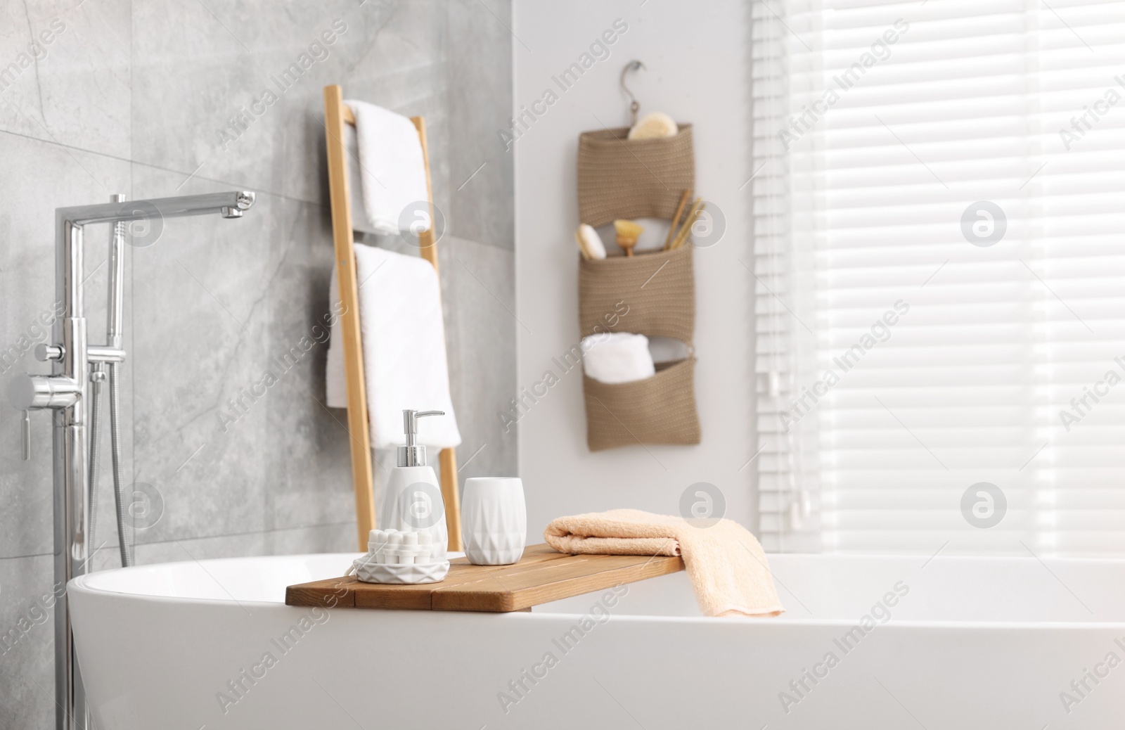 Photo of Set of different bath accessories and soap on tub in bathroom, space for text