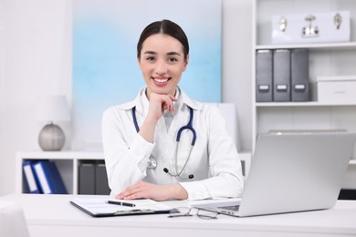 Photo of Medical consultant with stethoscope at table in clinic