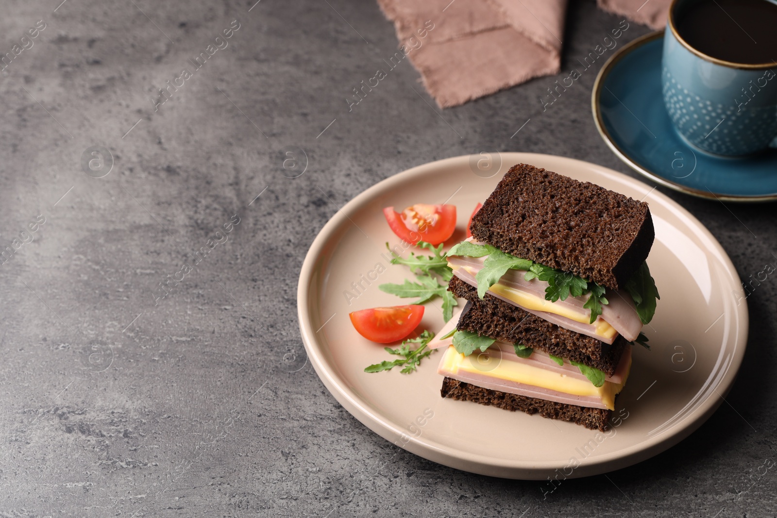 Photo of Delicious sandwiches with boiled sausage, tomato, cheese and arugula on grey table, space for text