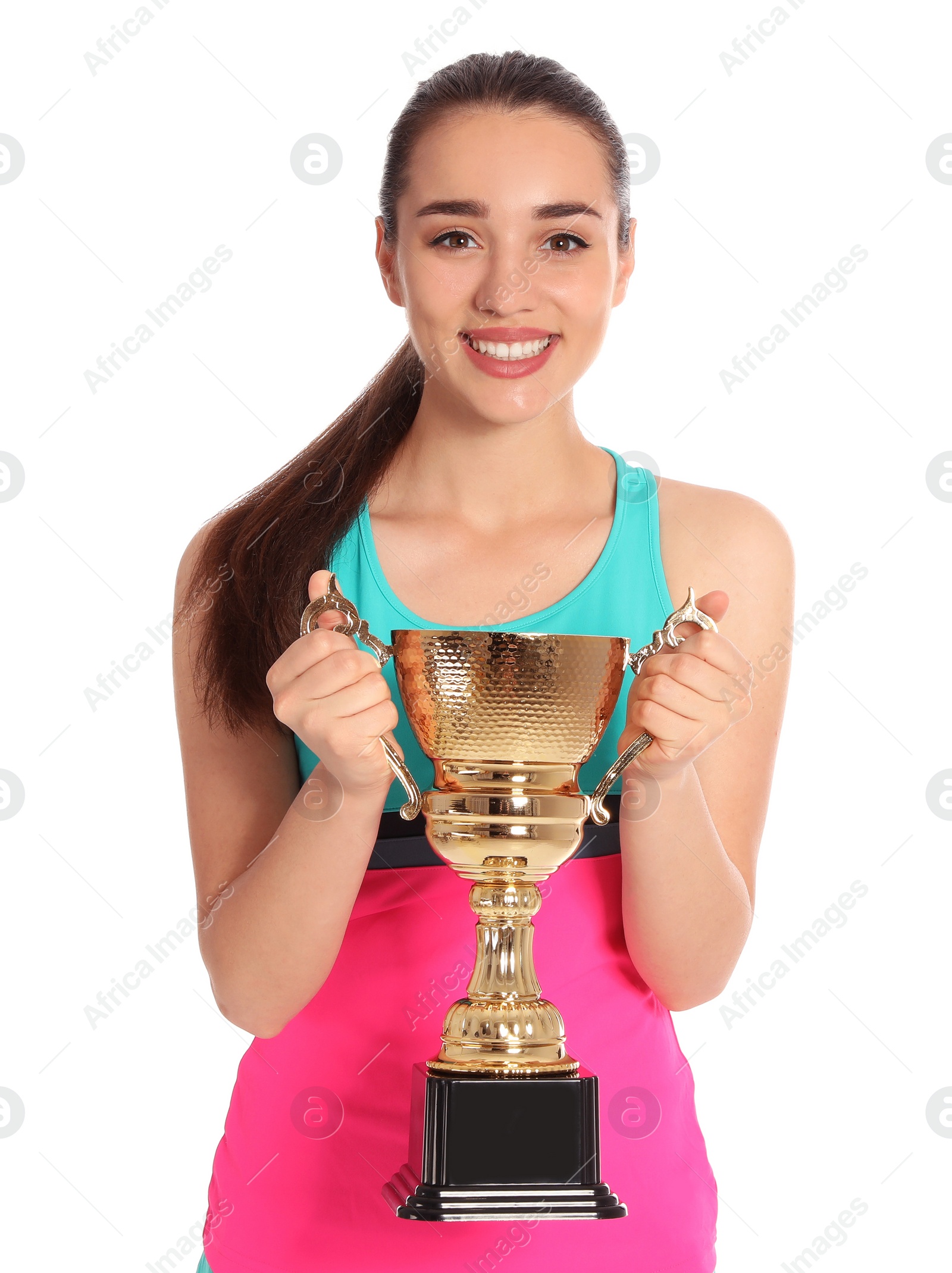 Photo of Portrait of happy young woman in tennis dress holding gold trophy cup on white background