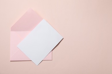 Photo of Letter envelope and card on beige background, top view. Space for text