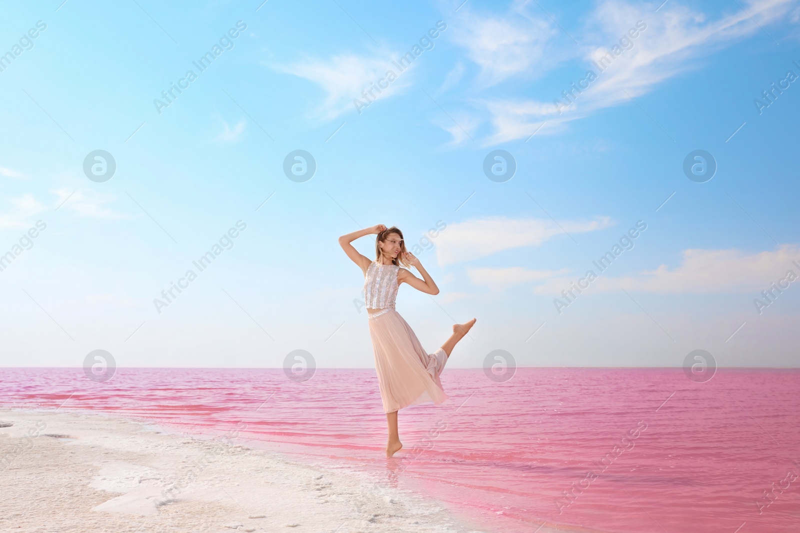 Photo of Beautiful woman posing near pink lake on sunny day