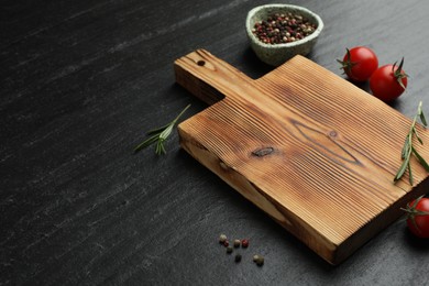 Photo of Wooden cutting board, fresh tomatoes and different spices on grey textured table. Space for text