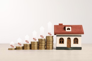 Mortgage rate. Stacked coins, arrows, percent signs and model of house