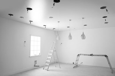 Empty room with stretch ceiling and ladders