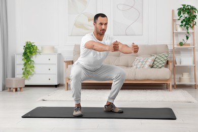 Photo of Man doing morning exercise on fitness mat at home