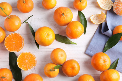 Photo of Fresh ripe tangerines on white wooden table, flat lay