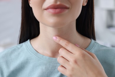 Photo of Endocrine system. Woman doing thyroid self examination indoors, closeup