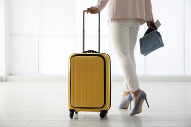 Photo of Businesswoman with yellow travel suitcase in airport