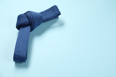 Photo of Karate belt on light blue background, space for text