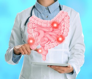 Gastroenterologist holding tablet computer on light blue background, closeup. Illustration of intestines with spots over device
