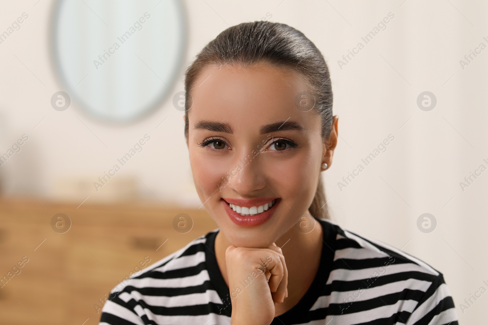 Photo of Portrait of beautiful young woman indoors. Attractive lady smiling and looking into camera