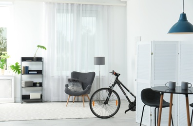 New bicycle behind folding screen in stylish room interior