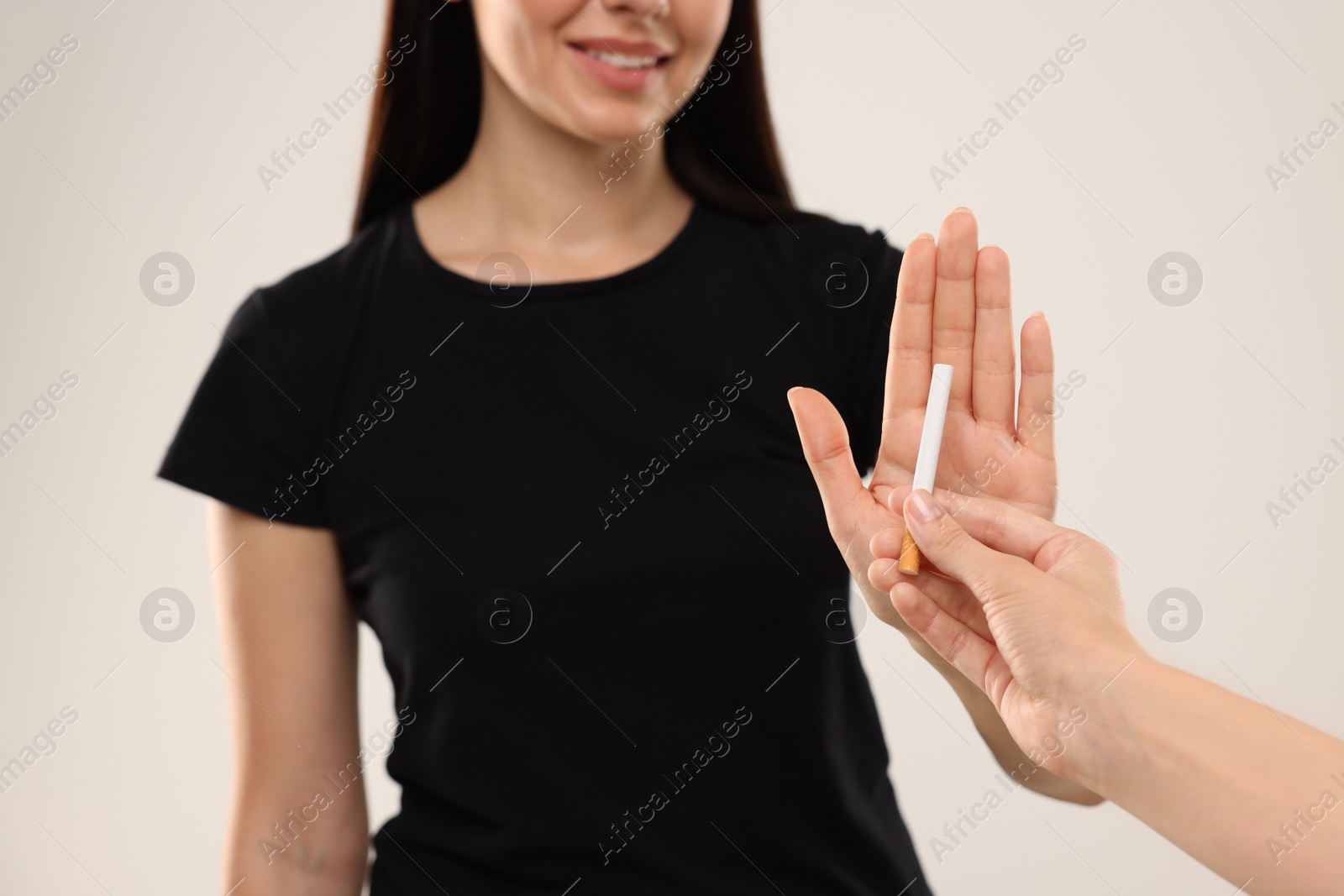 Photo of Stop smoking concept. Woman refusing cigarette on beige background, closeup