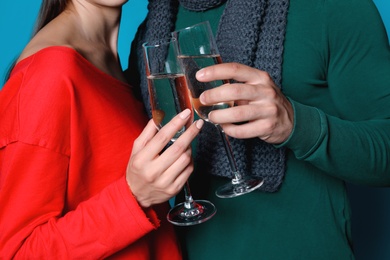 Photo of Young couple clinking glasses of champagne, closeup. Christmas celebration