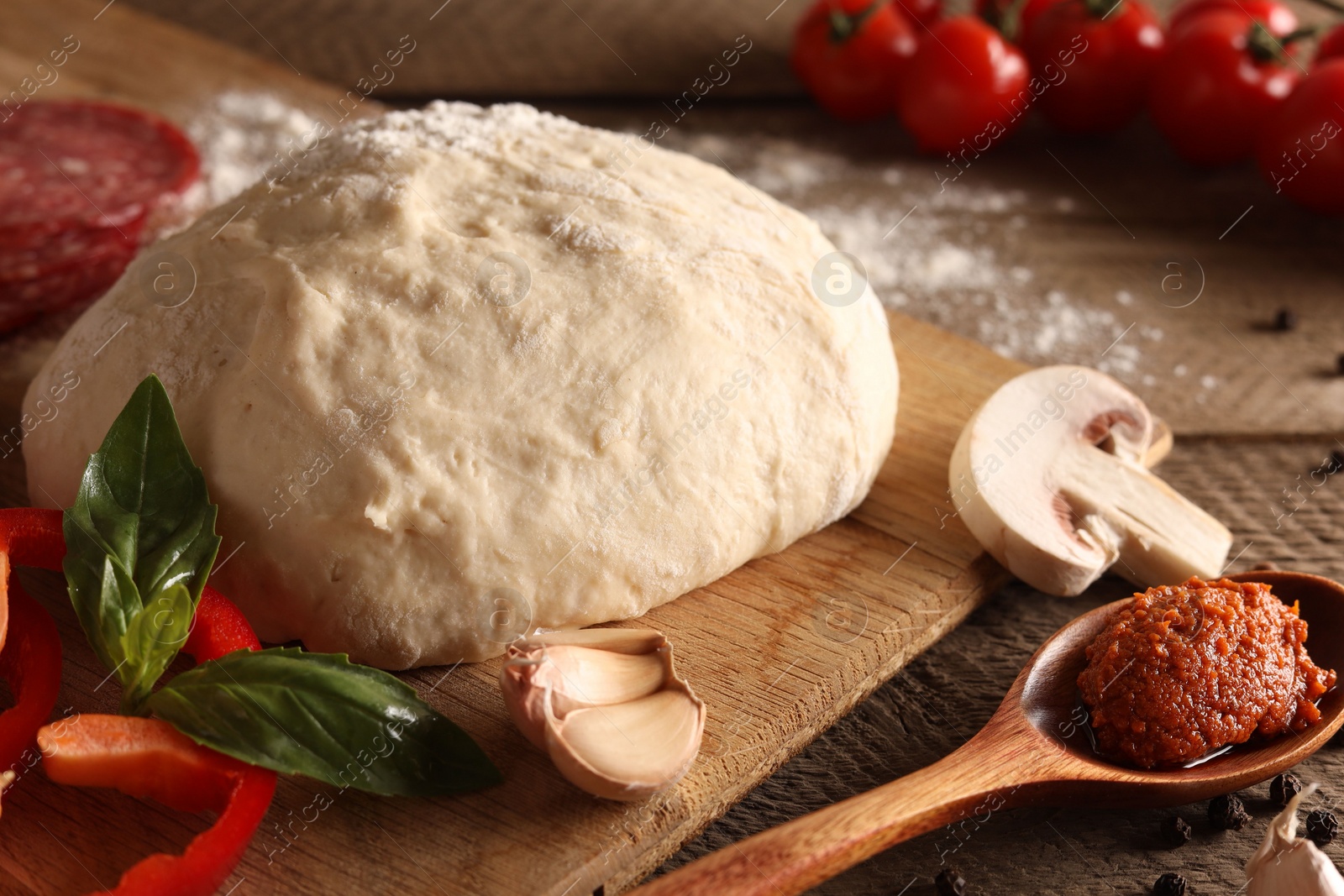 Photo of Pizza dough and products on wooden table, closeup