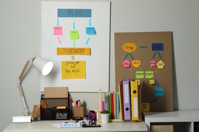 Photo of Business process planning and optimization. Workplace with lamp, colorful paper notes and other stationery on table