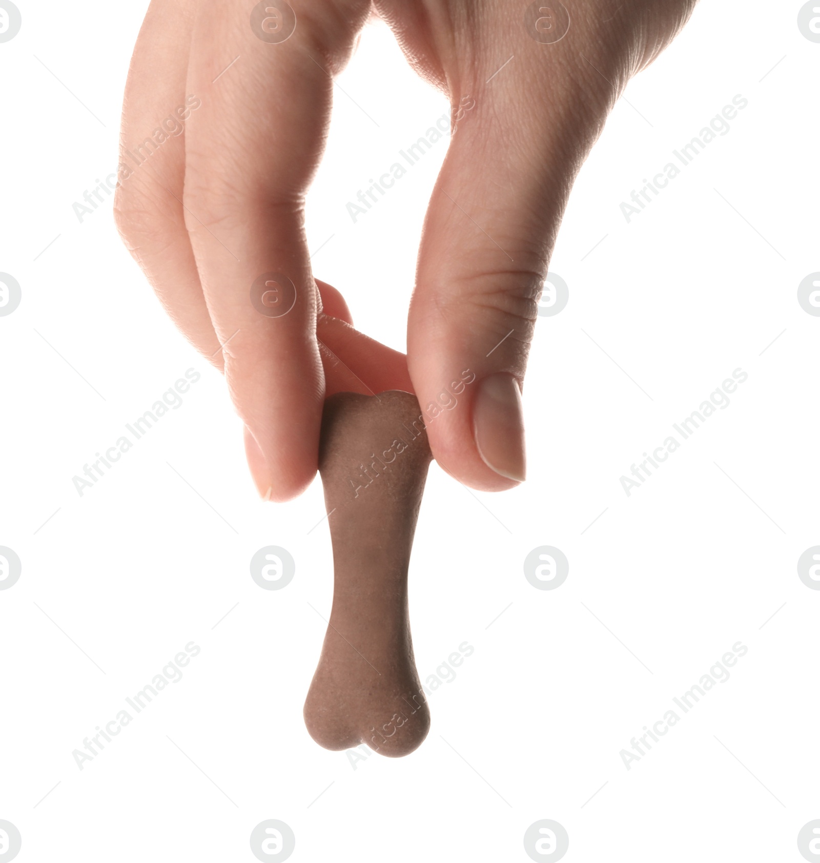 Photo of Woman holding bone shaped dog cookie on white background, closeup