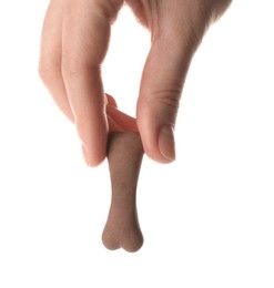 Woman holding bone shaped dog cookie on white background, closeup