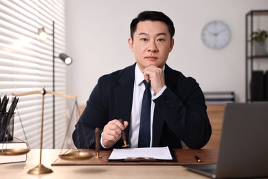 Notary stamping document at wooden table in office