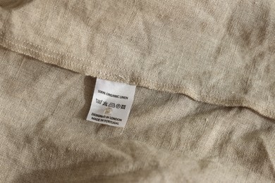 Photo of Clothing label on beige garment, closeup view